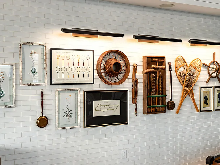Eclectic Wall Display Featuring Framed Art, Snowshoes, and Vintage Sports Gear