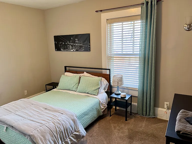 Guest room. Full bed, small dresser. Blinds and curtains.