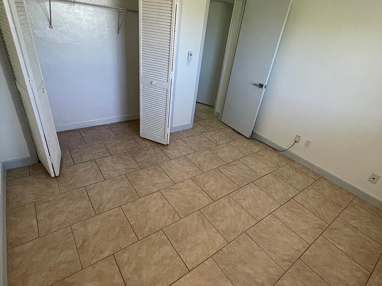 The guest bedroom has tile flooring, like the entire apartment.