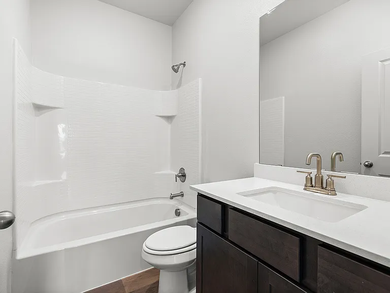 The secondary bathroom has a spacious vanity and a shower-tub combo.