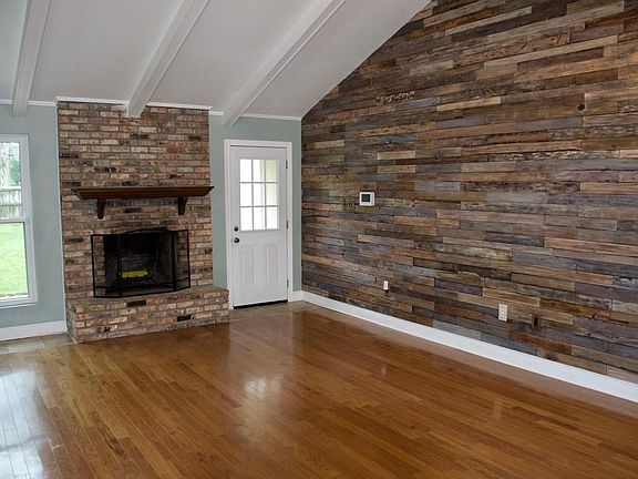 Den with wood floors and wood accent wall