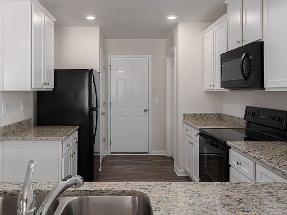Large white cabinets with crown molding add elegance and tons of storage to the room