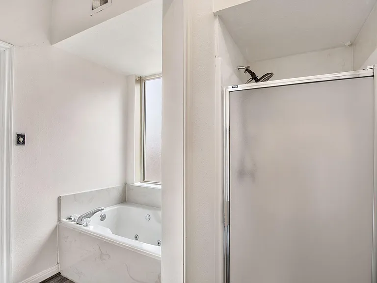 Private Bathroom with a tub/shower combo, frosted window for natural light, and easy-clean surrounds for low-maintenance use.