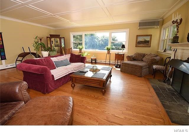 This enormous living room features wooden ceiling, brick fireplace and enormous windows with seasonal river views.