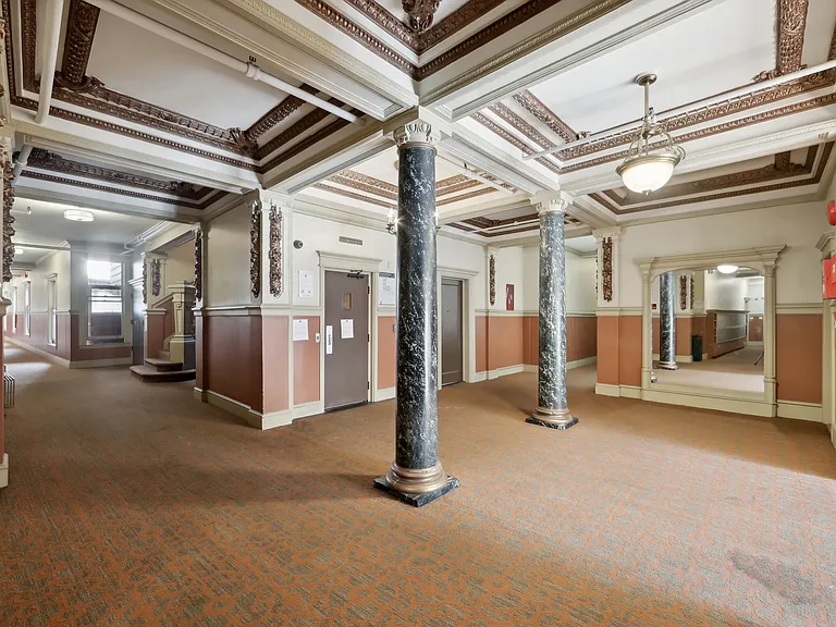 Grand hallway with a high ceiling illuminated by a chandelier
