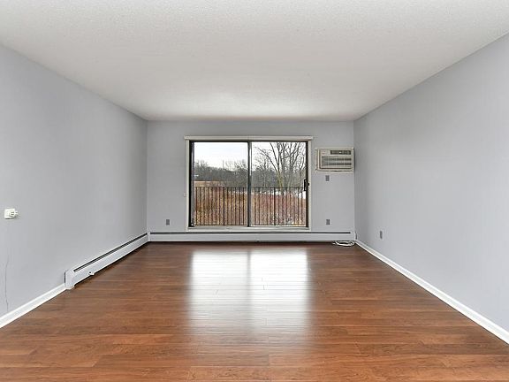 Large living room with new wood like floors into dining room. New paint throughout unit.