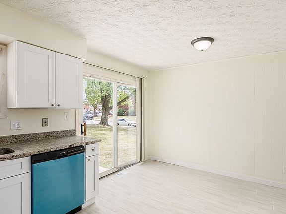 Kitchen with tile floor, granite countertops and backsplash, new cabinets, and new appliances. Ample space for a dining table in the kitchen.