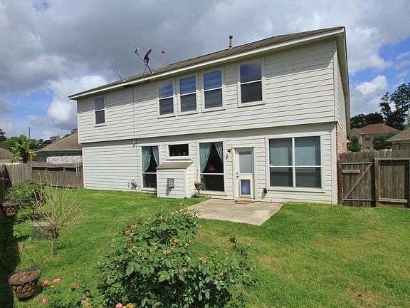 This is the Back of the Home with a Connected Patio and lush lawn.