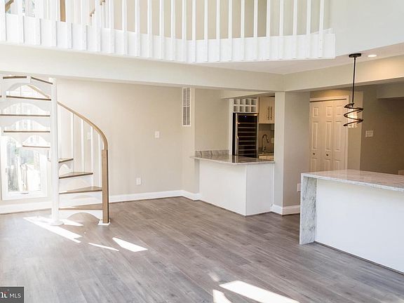2 Story family room with floor to ceiling windows and skylights. Spiral secondary stairs leads to upstairs gallery and sitting area.
