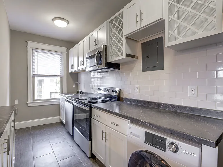Renovated kitchen with modern finishes and washer/dryer