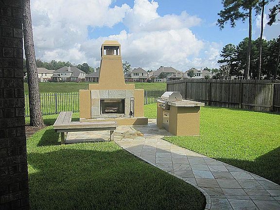Outdoor fireplace complete with sitting area and built in grill!  This home sits on one of the larger lots in the neighborhood and overlooks the detention pond (normally dry).  Great walking area!
