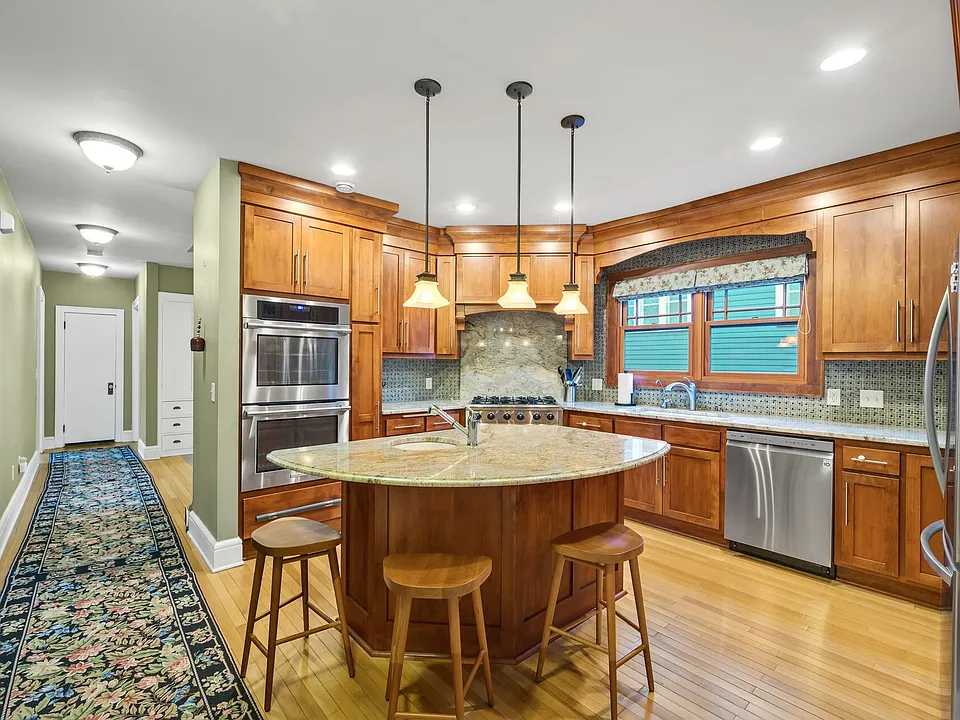Kitchen with prep sink, dual ovens, 6 gas burners. Fireplace room off to the left with gas fireplace and bookshelves.