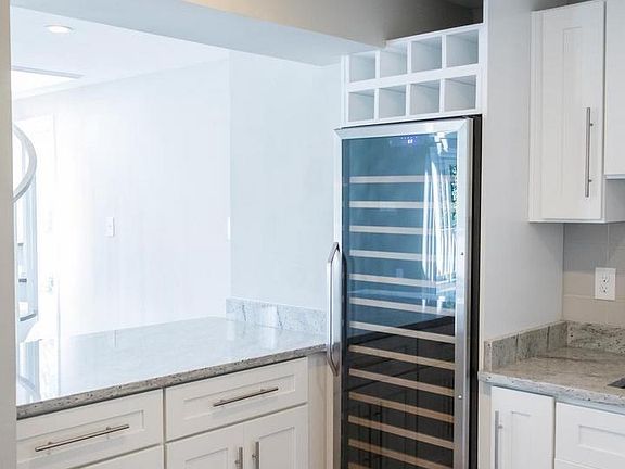 Wine bar extends from the kitchen with wine cooler and secondary kitchen.