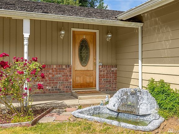Curb appeal with inviting covered front porch entry lined with rose bushes to greet your guests.