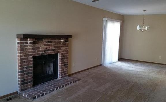 Living room has a fireplace and new carpeting. Open to dining room.