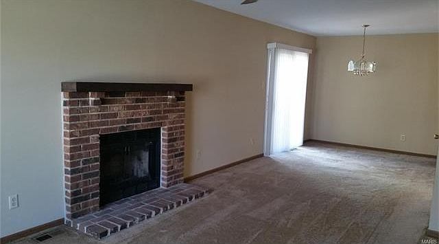 Living room has a fireplace and new carpeting. Open to dining room.