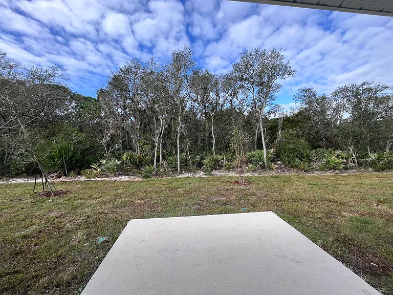 Conservation land in backyard with white vinyl fencing along neighboring sides