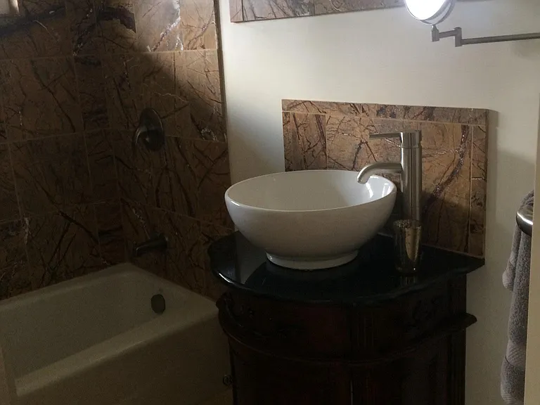 bathroom has a sink, tub and shower