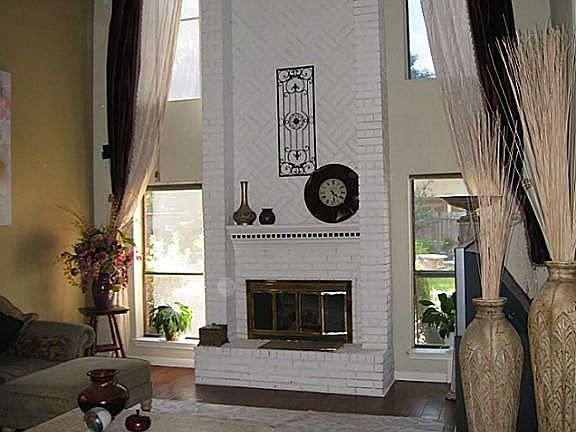 Brick fireplace floor to ceiling and wall of windows looking to back