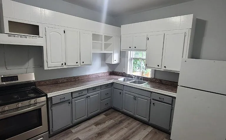 Clean, open and spacious kitchen with back door that leads to a cover back porch