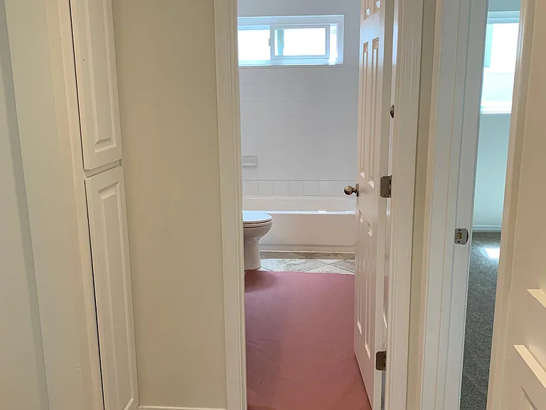 from hall into 2nd bathroom with shower over tub & double sink vanity