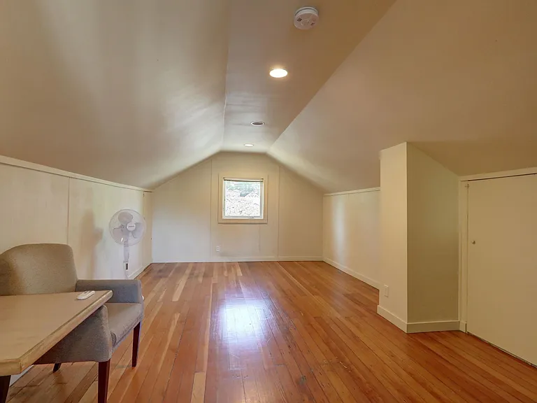 Upper floor bedroom, real wood floors, well lit.