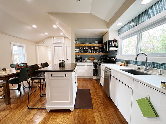 Open concept kitchen and dining space with a vaulted ceiling; can be configured for large dinner parties (as seen) or as a secondary living/office space depending on the priorities of your lifestyle