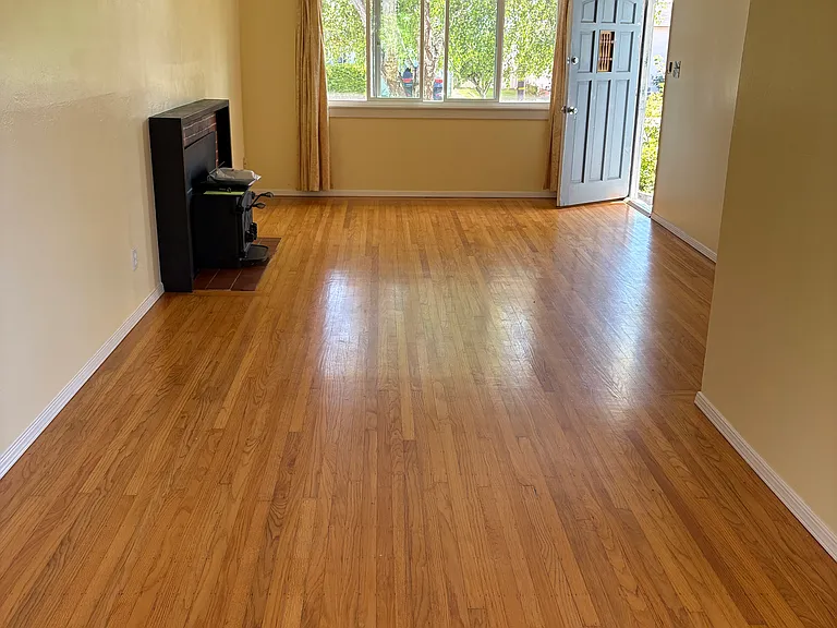 Living room, looking towards front door. Hardwood floors throughout.