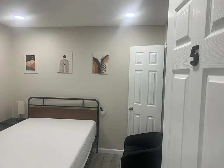 Full size bed and seat that faces the TV