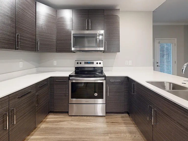 The Redbud kitchen offers sleek cabinetry, a double sink, and stainless steel appliances in the open-concept kitchen. The Redbud kitchen offers sleek cabinetry, a double sink, and stainless steel appliances in the open-concept kitchen.