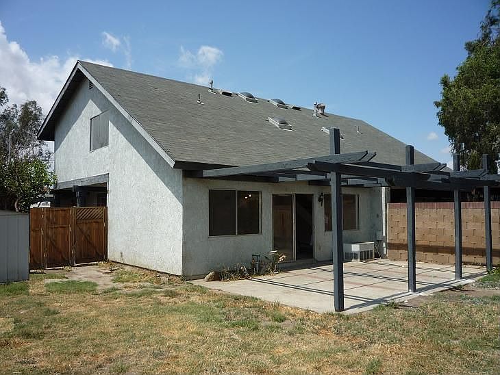 Covered rear patio in large yard with mountain view
