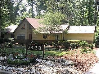Front of house, long sloping driveway and 2-car garage