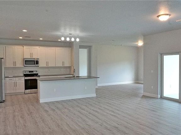 Great room view to kitchen.  100% waterproof vinyl wood look flooring