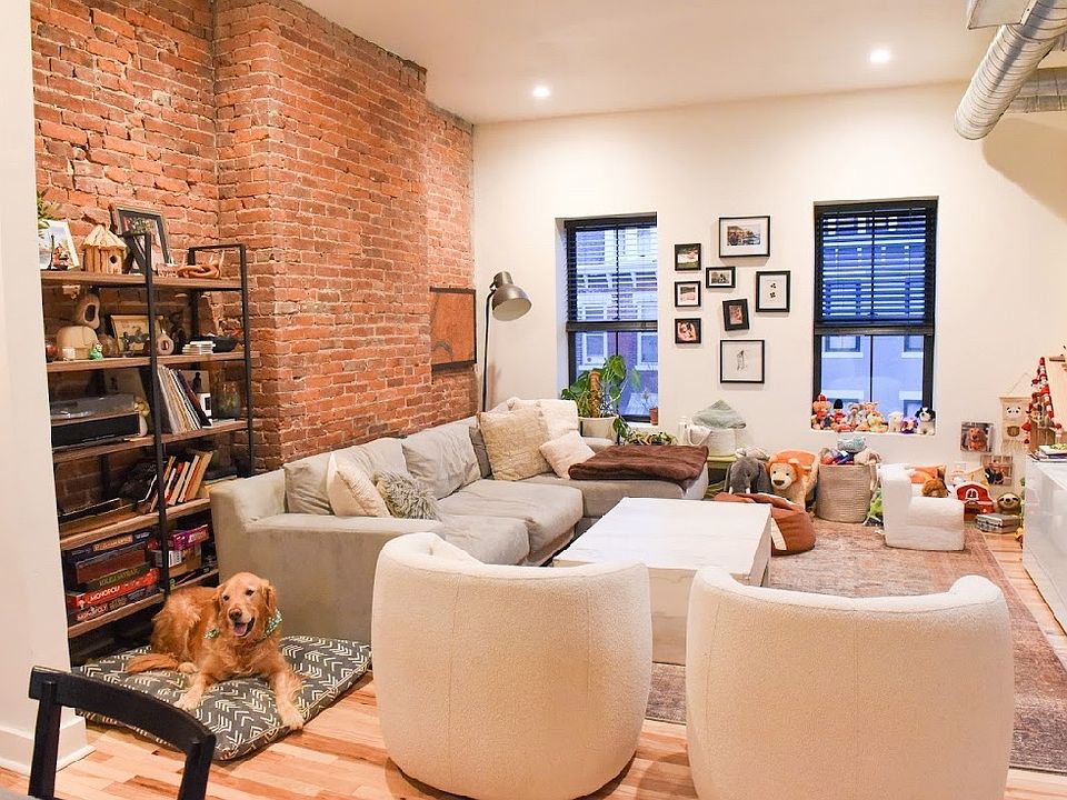 living room with large windows and brick accent wall