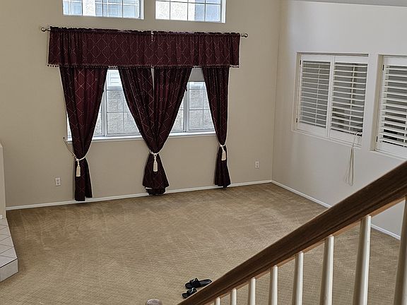 Large Living room with vaulted ceiling. Designer drapes included.