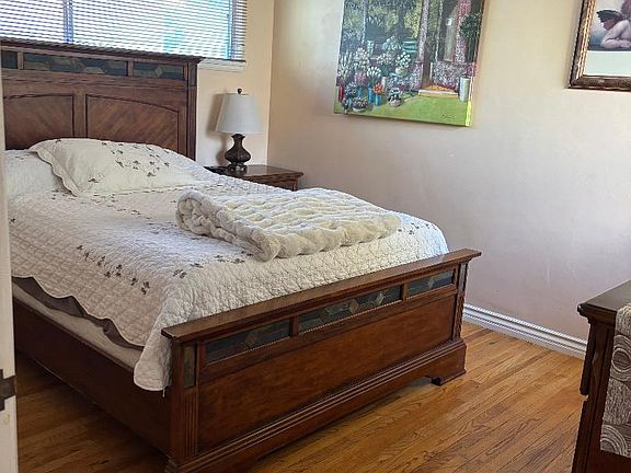 Furnished Bedroom with side table, and dresser.