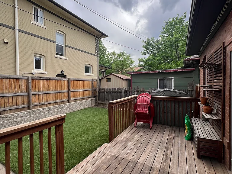 The backyard has a large deck, astroturf, and a pavered patio area.