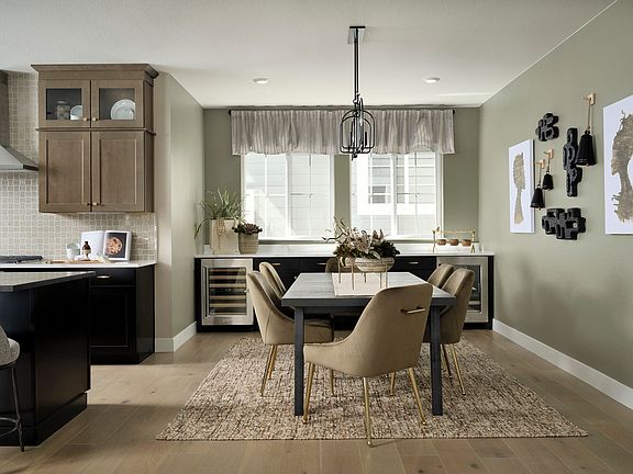 A modern and cozy kitchen-dining area with wooden cabinets, a large dining table surrounded by beige