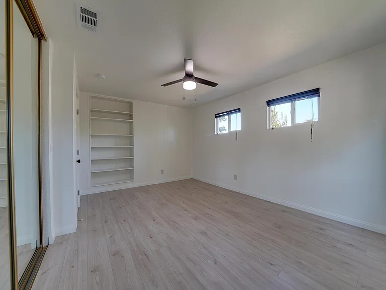 Master bed with new fan, pain, and flooring. Pre-built shelves in frame.