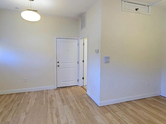 view from living room toward entrance, bathroom, and in-unit laundry