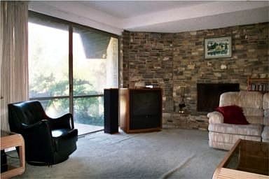 Step down family room with fireplace and view of private backyard