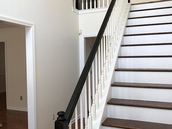 View of two-story Foyer with a peak of the front sitting room, office, or library.