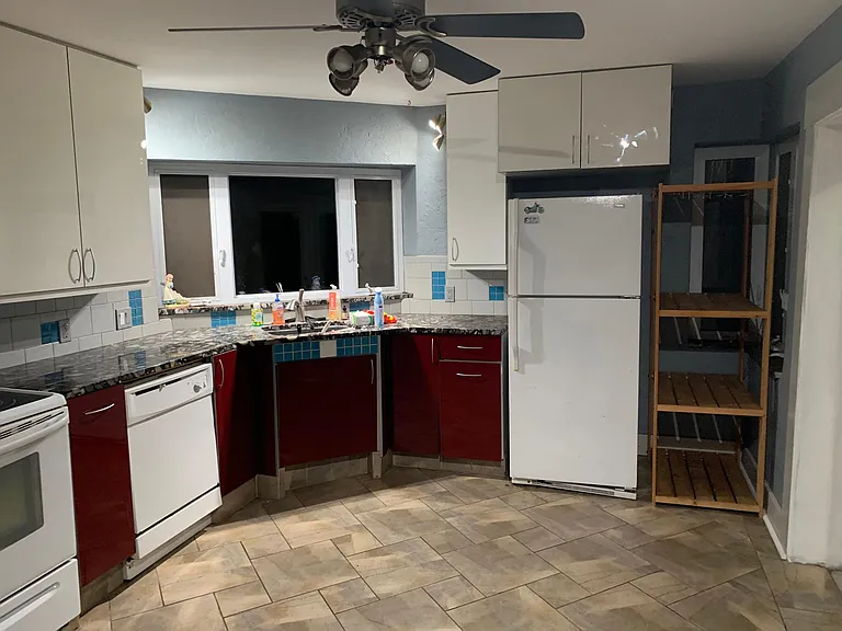 Marble counter and red lacquer cabinets. Hi. Lots of storage. Tile floor