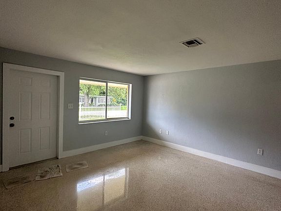Spacious living room with polished terrazzo floors. Impact windows and central a/c