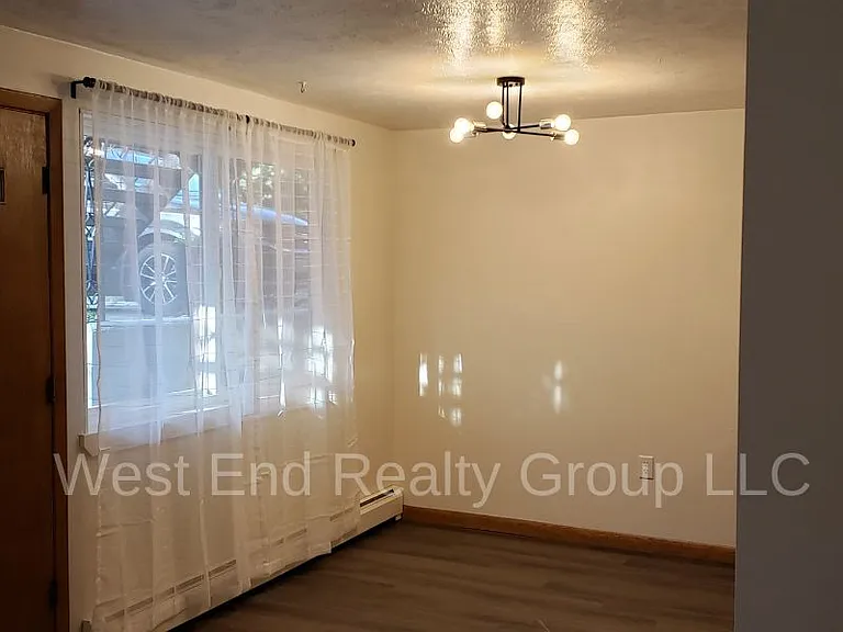 Dining room with new Sputnik light fixture, sheers and blinds. New luxury vinyl plank floor.