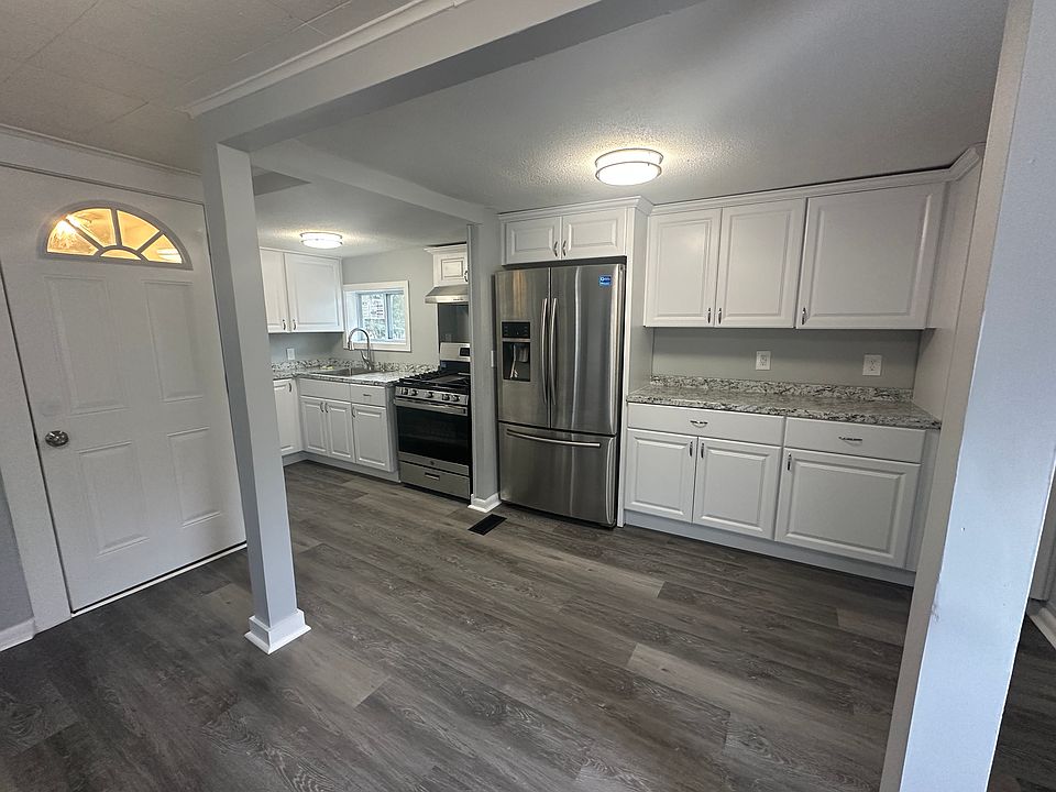 Fully renovated kitchen featuring stainless steel appliances, new cabinetry, granite-style countertops, and updated fixtures.