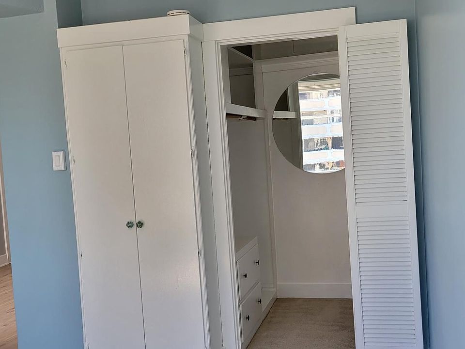 Door from living room, cupboard and opening to walk in closet in bedroom