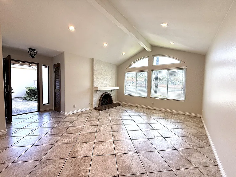 Living room with fireplace and front door open to entry.