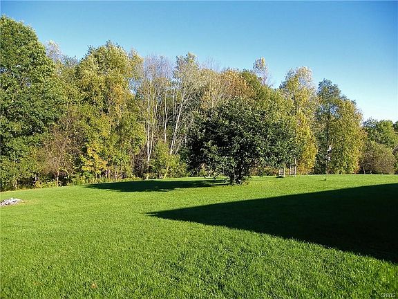 Huge Back Yard slopes down to wooded acreage in back of property