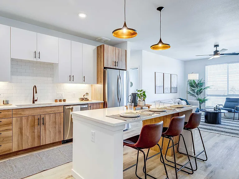 This open-concept apartment home features a modern kitchen with quartz countertops, stainless steel appliances, and stylish living space finishes.